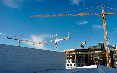 Construction site featuring a partially built structure with scaffolding and construction materials visible around it.