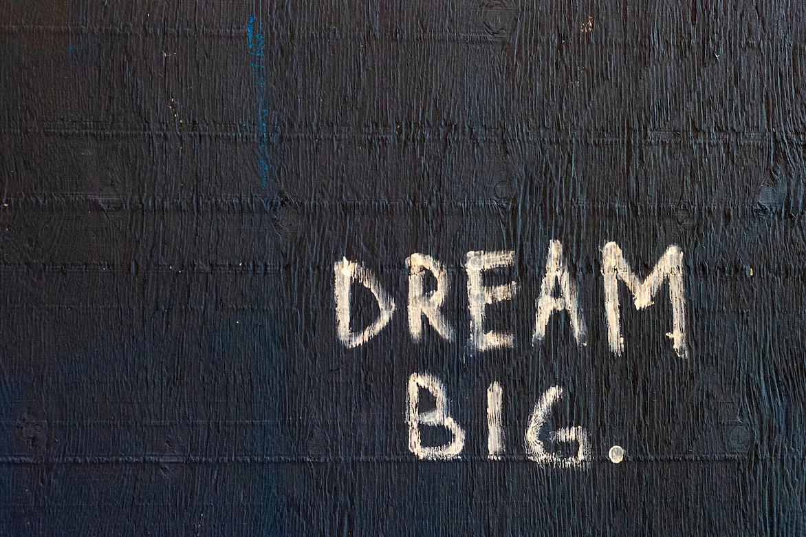 The words 'dream big' written on a black wall