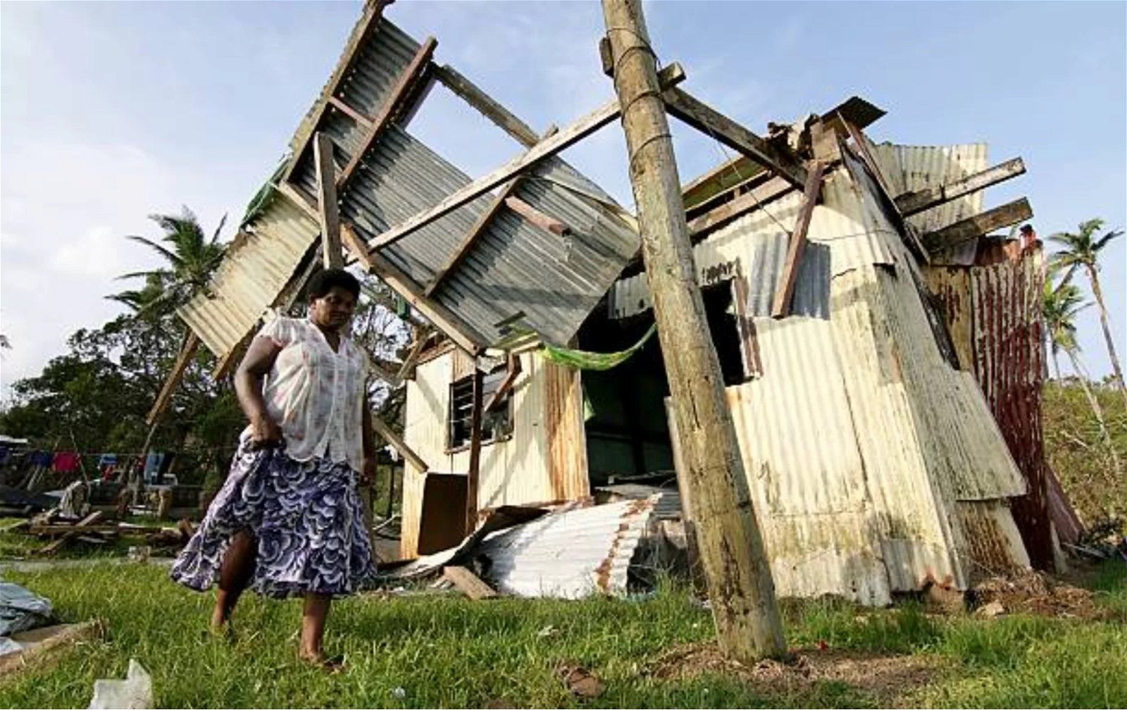 PHOTO of A woman from the village of Namena in Tailevu walks in front of her damaged house after Cyclone Winston swept through the area