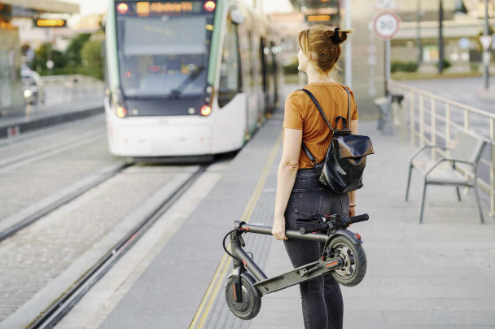 Figure 5: Person holding an e-scooter waiting for a tramway. Picture courtesy Westend61